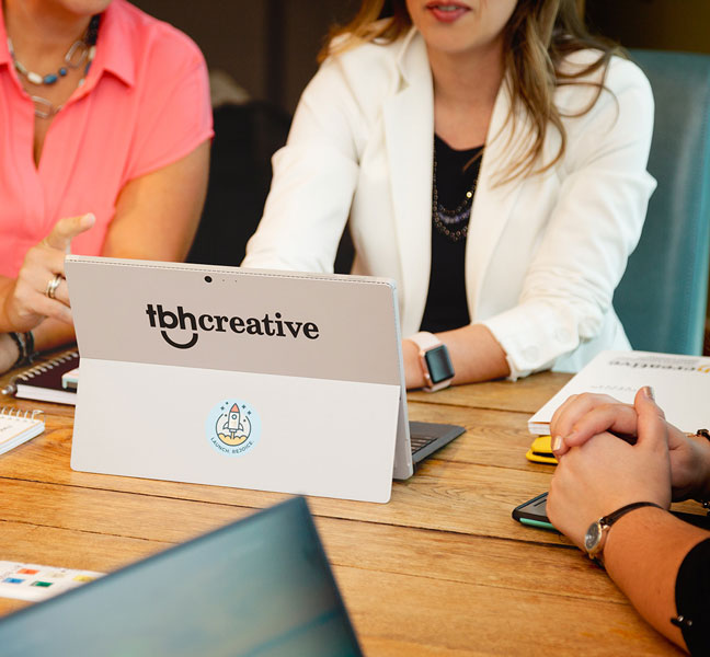 Marketing professional using laptop in strategy meeting